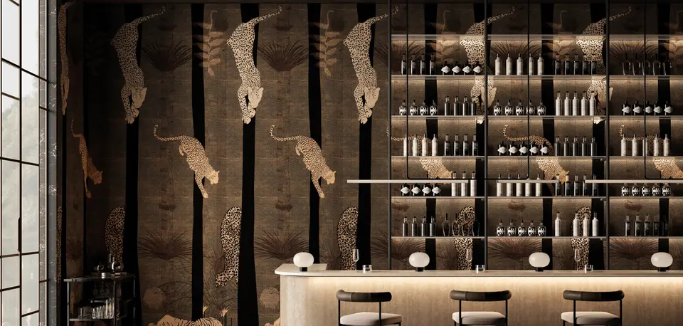 Un bar con le pareti scure disegnate a ghepardi che saltano fra i tronchi, e gli scaffali di bottiglie