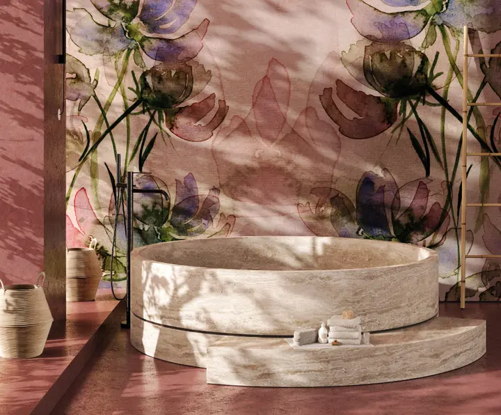 Un bagno con la vasca di pietra davanti a una parete di grandi fiori ad acquerello, rosa e viola